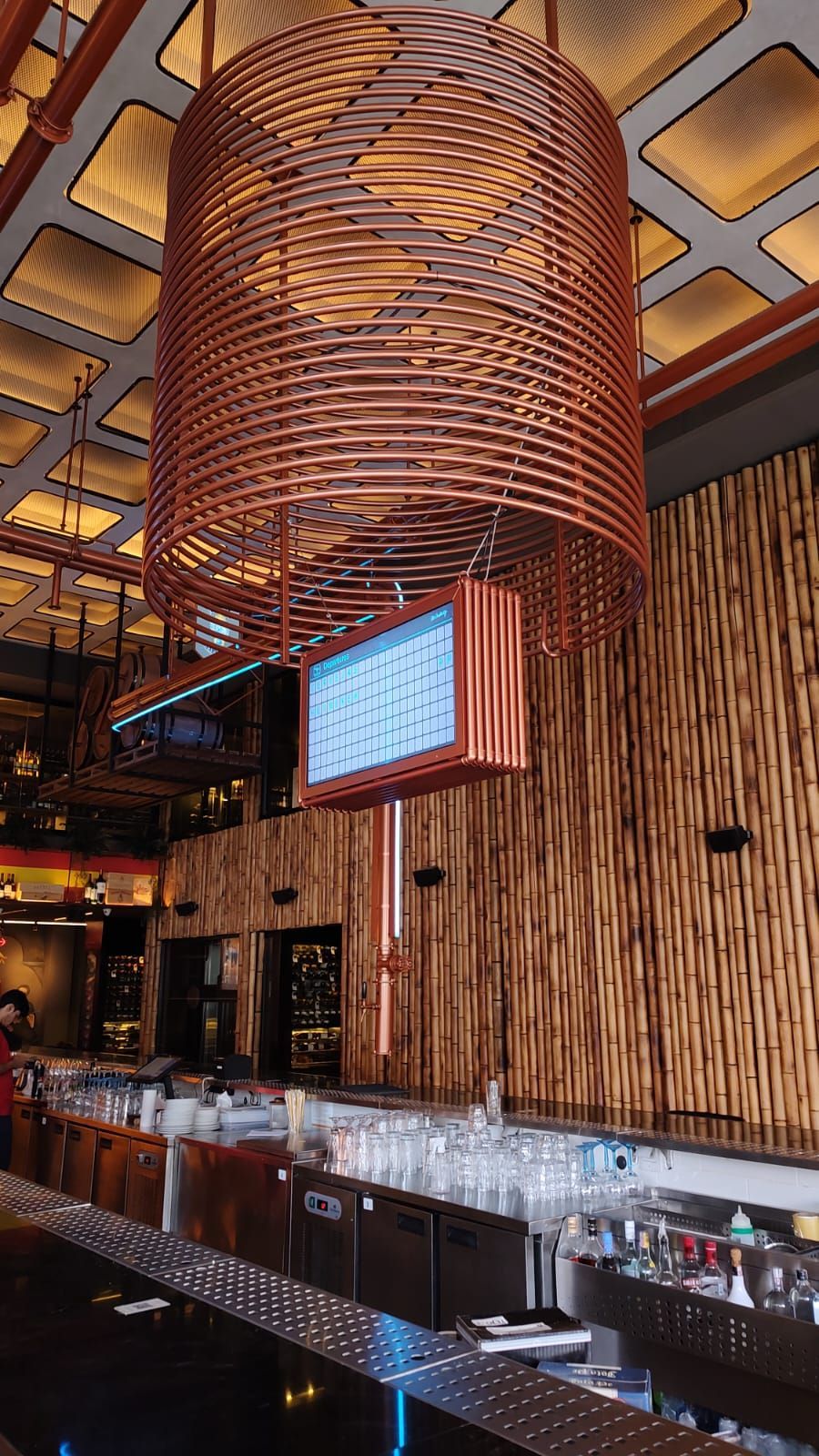 Um bar com um lustre de cobre pendurado no teto