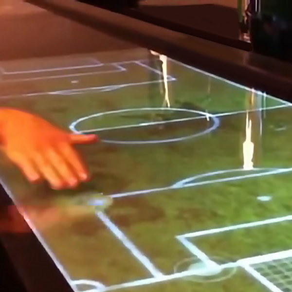 Uma pessoa está tocando um campo de futebol em uma tela