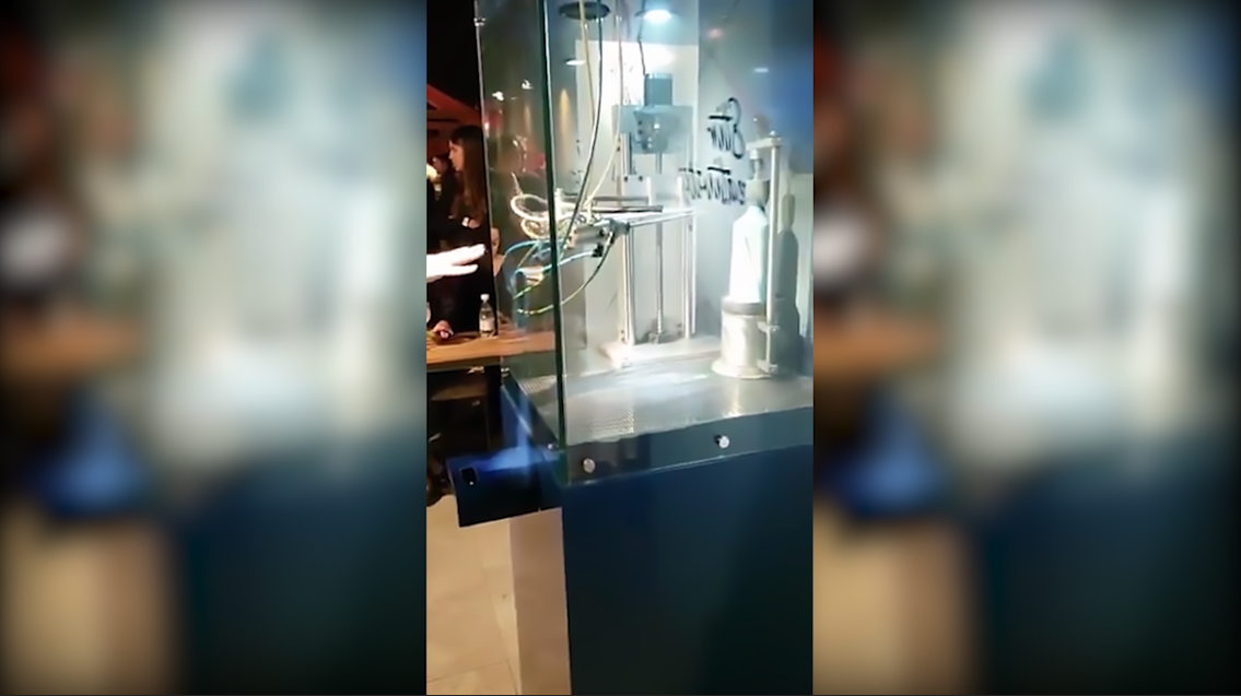 Um grupo de pessoas está em pé em frente a uma porta de vidro.