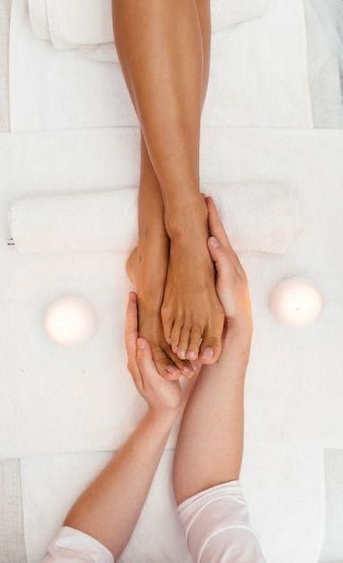 Donna che si fa truccare gli occhi, riflessa in uno specchio, con la tavolozza del trucco in primo piano.