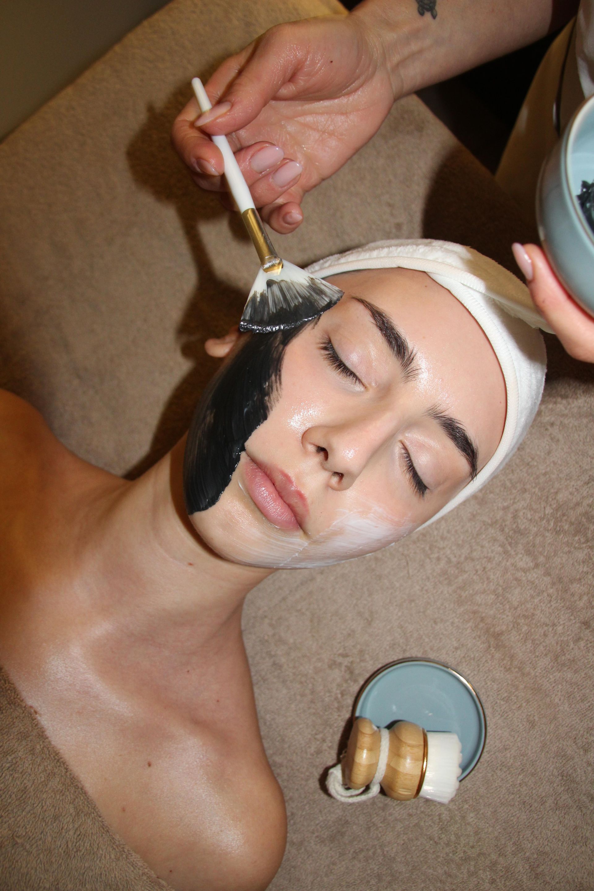 Donna sottoposta a iniezione di filler per le labbra in una clinica; il primo piano mostra l'ago che penetra nel labbro.