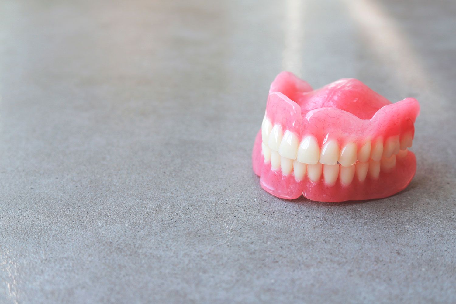 Full Dentures On A Grey Table