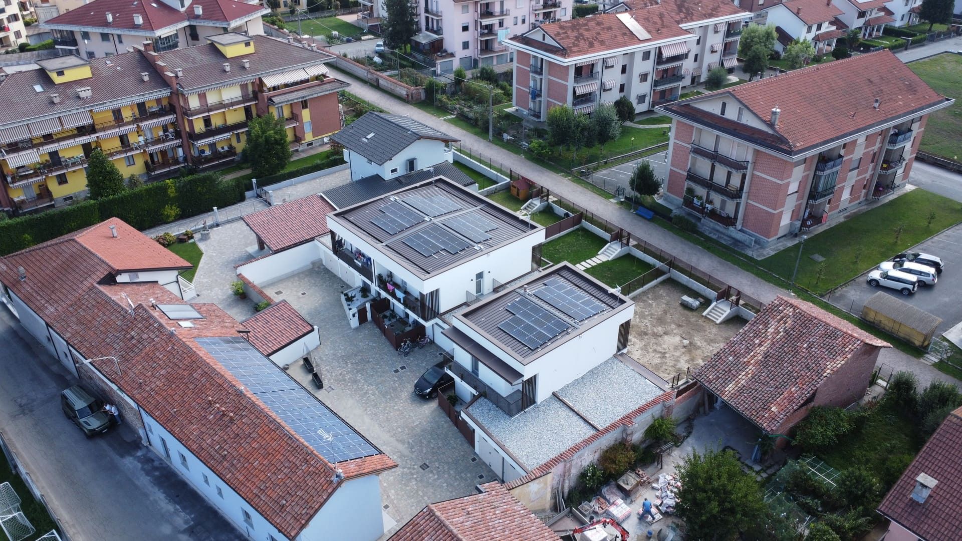 Callimaco - Centallo. Vista aerea di edifici con tetti di tegole rosse e di moderne strutture.