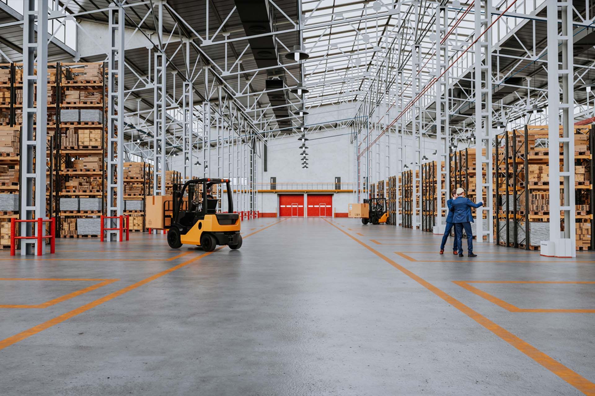Ristrutturazione industriale. Interno di un magazzino con carrelli elevatori, pallet accatastati.