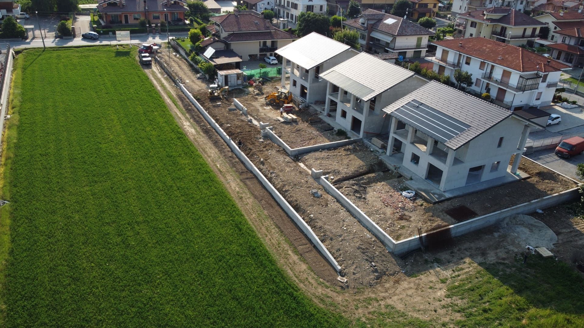 Cassandra - Roata Chiusani. Cantiere: Nuove case con pannelli solari, vicino a un campo.