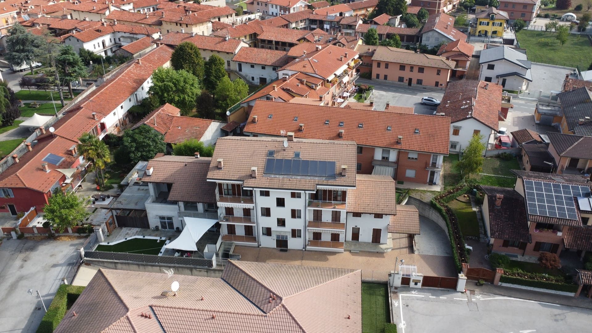 Isotta - Villafalletto. Vista aerea di edifici con tetti di tegole rosse in una città italiana.