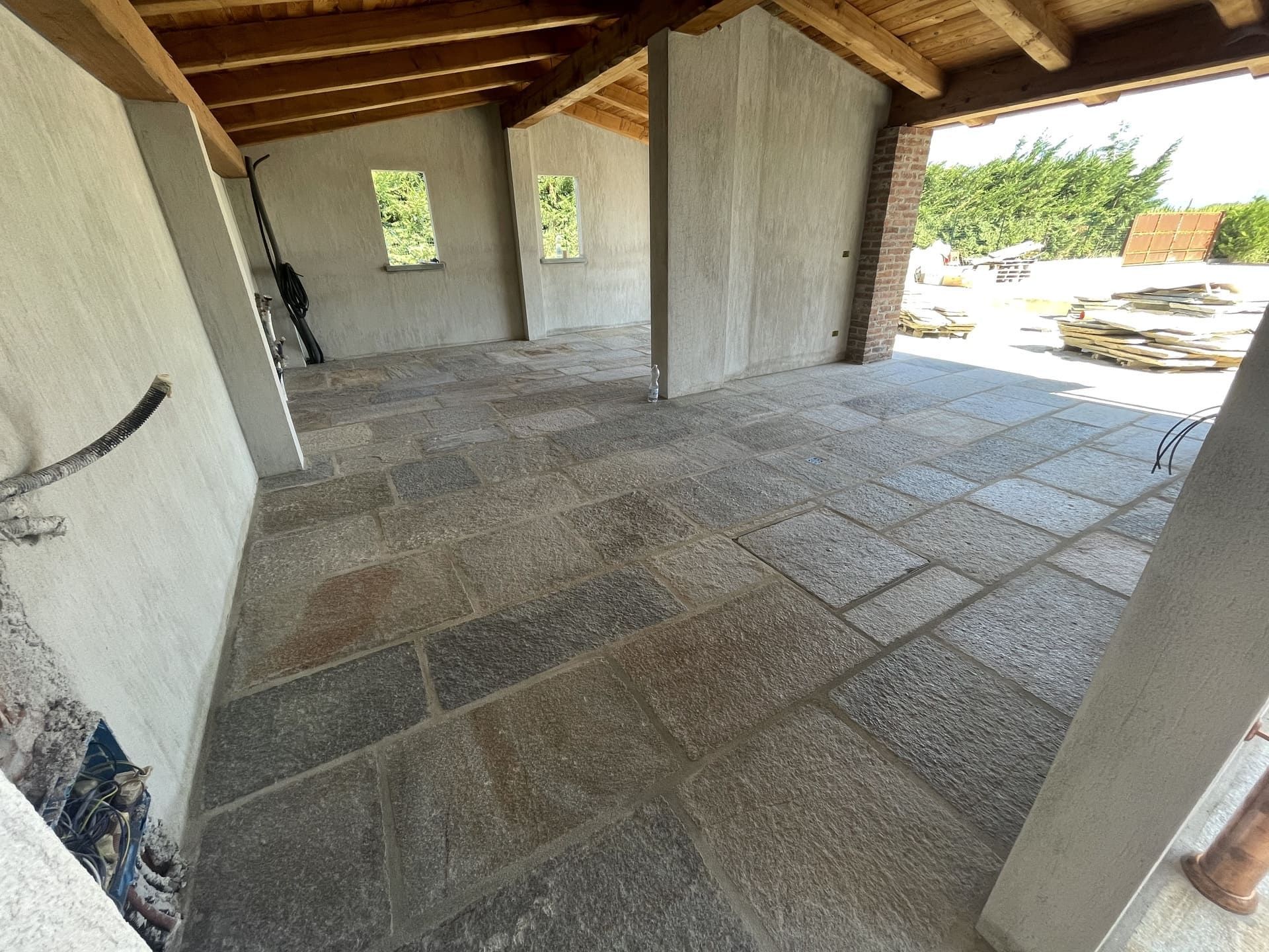 Pavimentazione in pietra di pietra grigia, pareti grezze, travi in ​​legno e due piccole finestre.