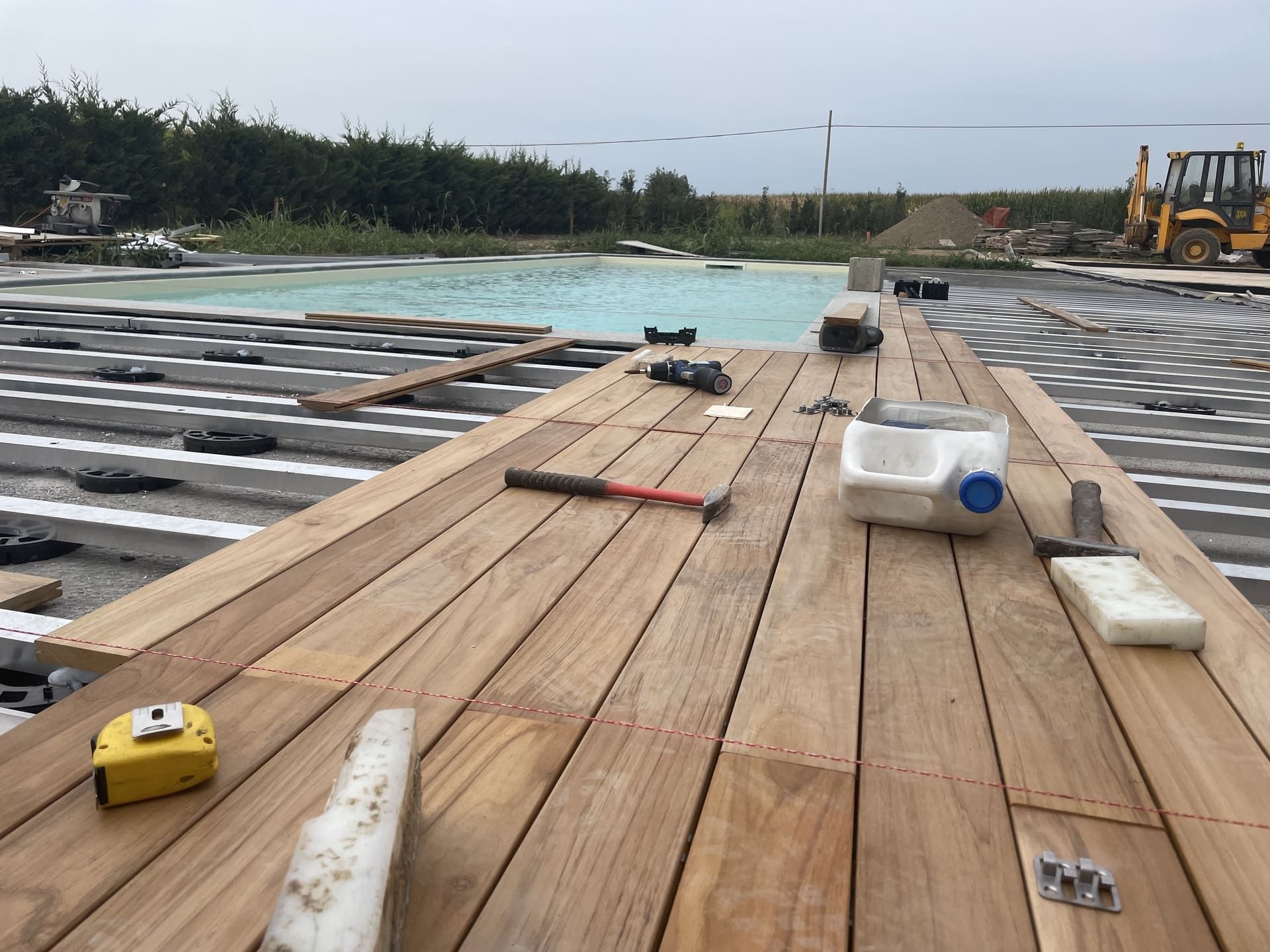 Pavimentazione in pietra con una piscina sullo sfondo.