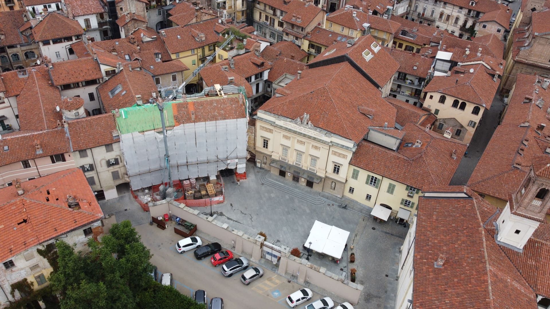 Ristrutturazione a Savigliano. Vista aerea di una piazza cittadina europea con tetti di tegole rosse