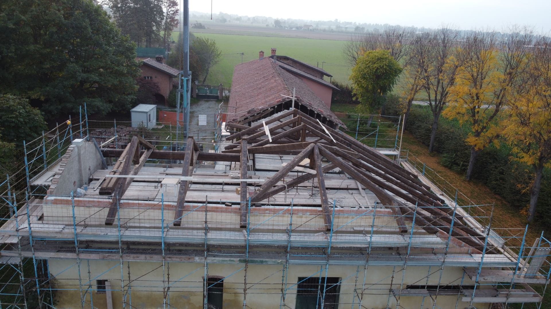Edificio in costruzione; tetto parzialmente rimosso, impalcature che circondano la struttura.