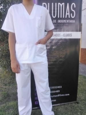 Persona que viste un uniforme médico blanco de pie delante de una pancarta.