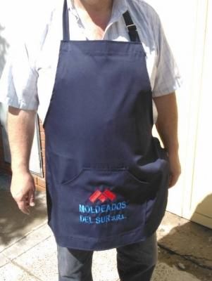 Person wearing a navy apron with embroidered logo 