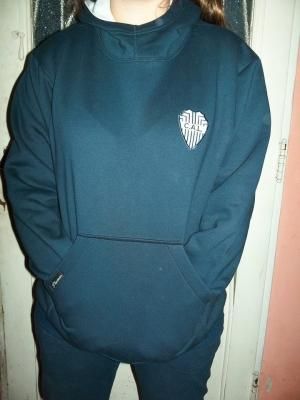 Persona que lleva una sudadera con capucha azul oscuro con un bolsillo delantero y un pequeño logotipo en el pecho.