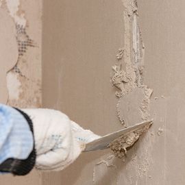 Stucco Repair — Hand with Spatula Leveling the Plaster in Brick, NJ