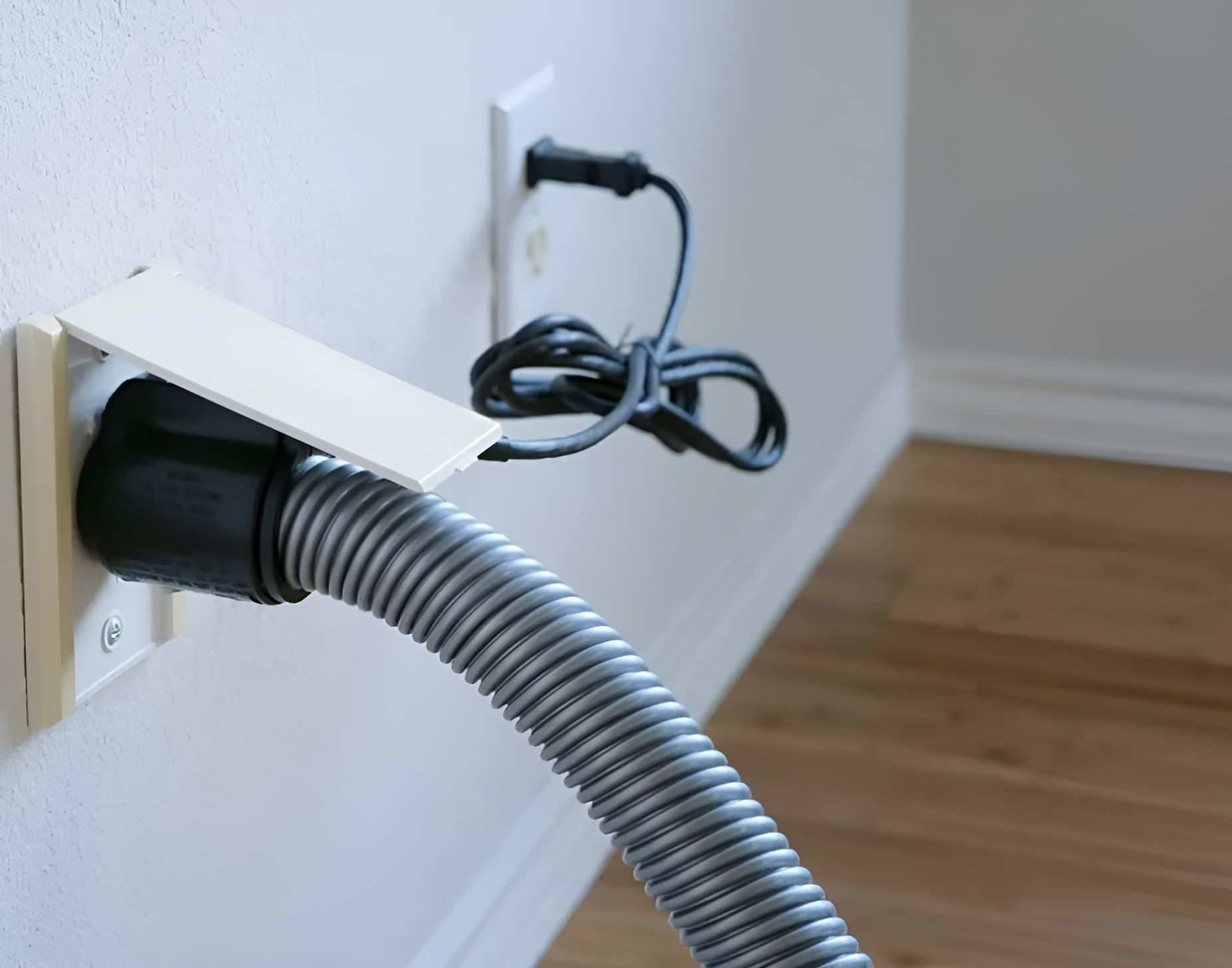 A Vacuum Hose is Plugged Into a Wall Outlet — CTE Systems In Taree, NSW