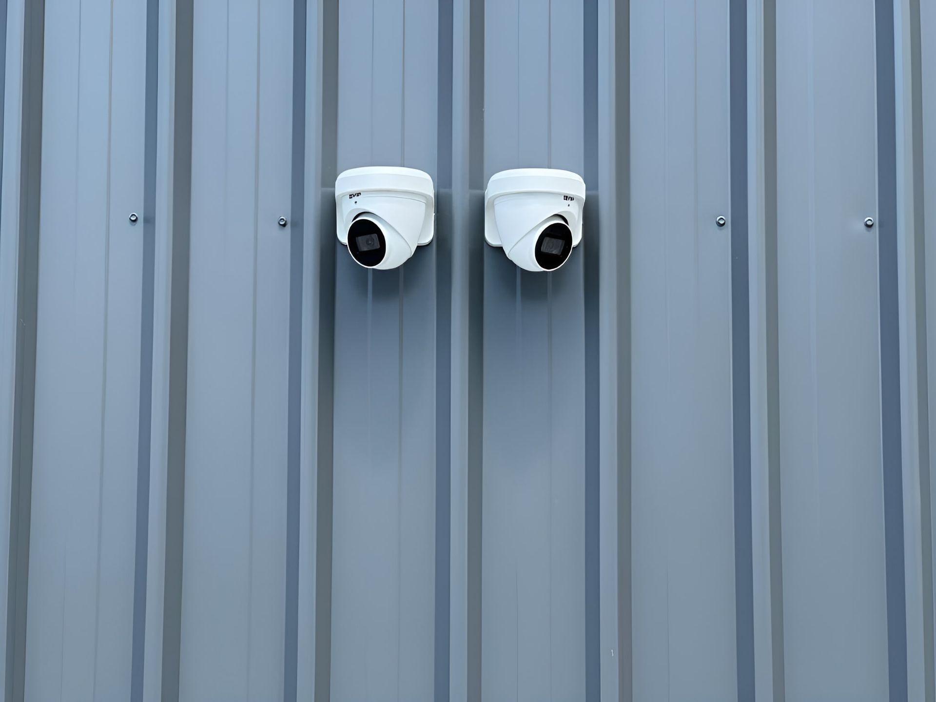 Two Security Cameras Mounted on a Gray Metal Wall — CTE Systems In Tuncurry, NSW