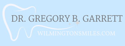A logo for a dentist named dr. gregory b. garrett
