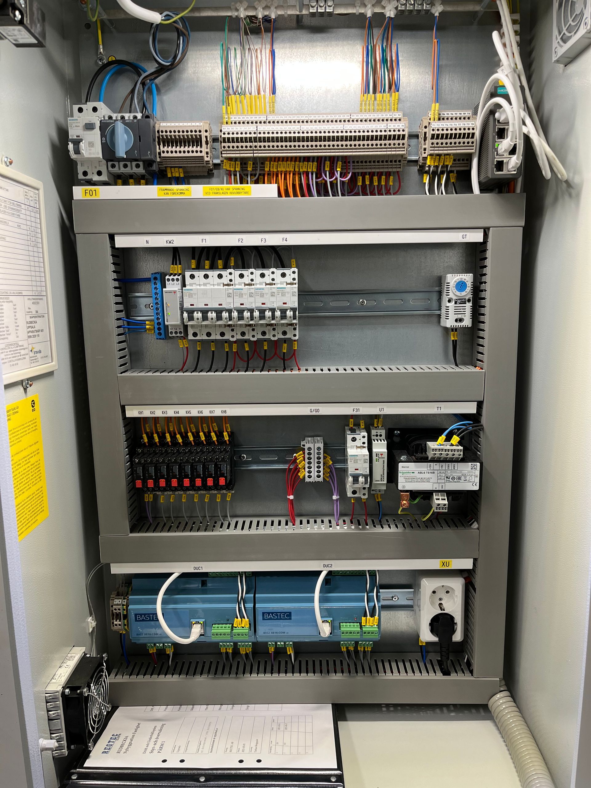 En mycket stor elpanel med många ledningar som kommer ut ur den.