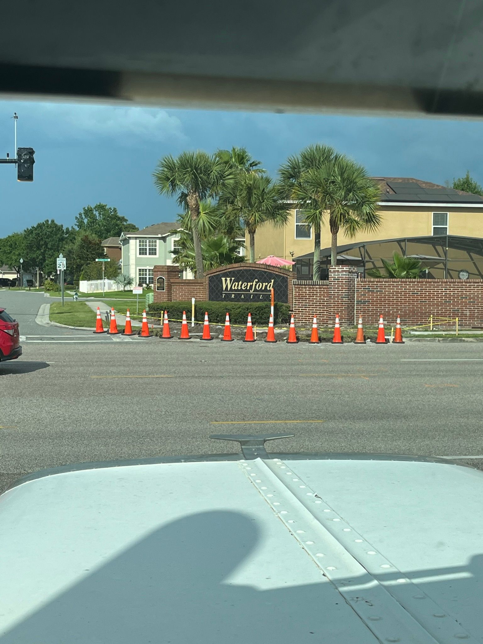 A car is driving down a street with a lot of traffic cones