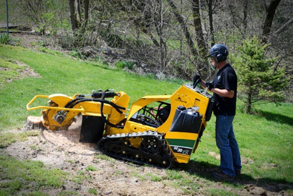 Worker operating a stump grinder in DeBary, FL as part of Samuel Site Service’s land clearing services.