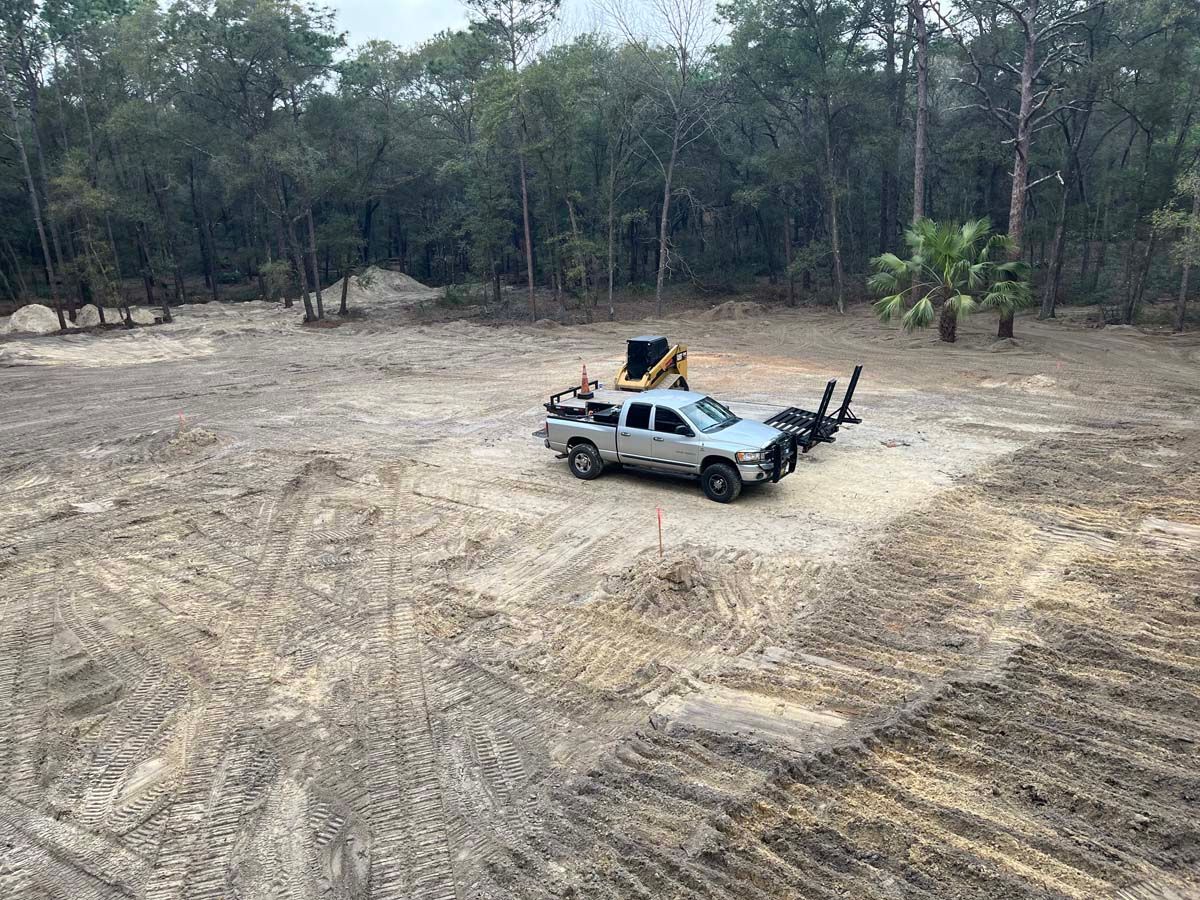 A truck is parked in the middle of a dirt field.