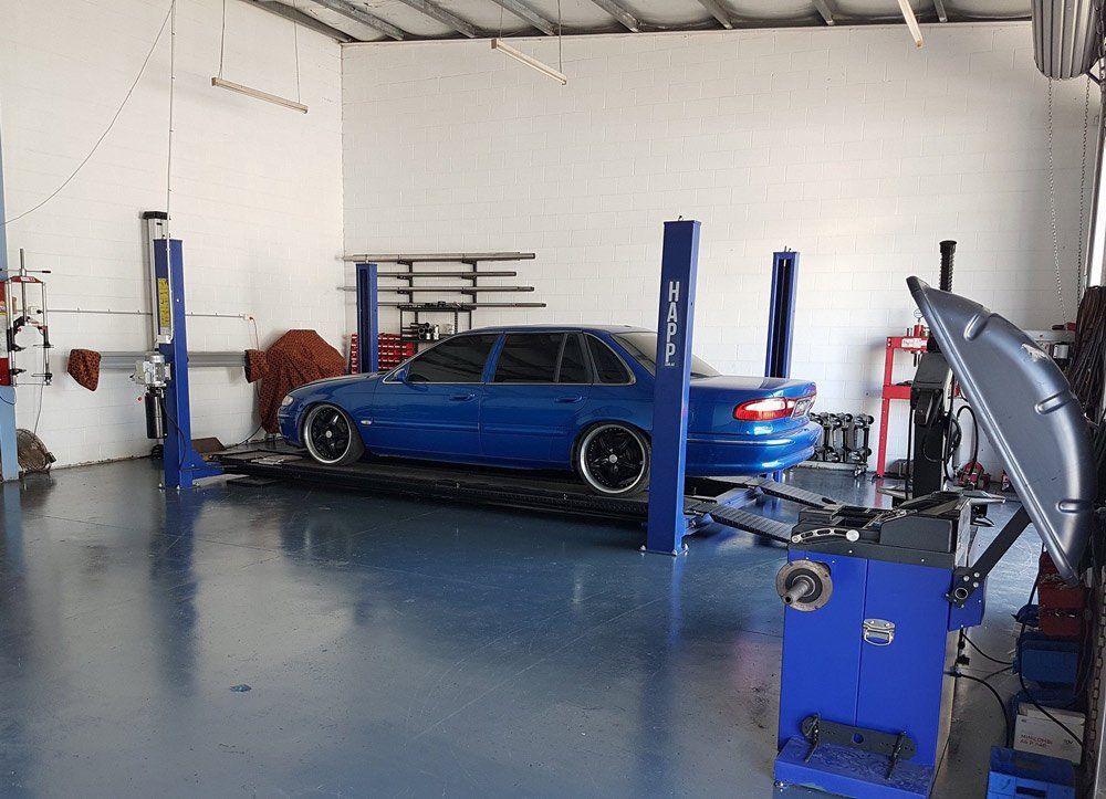 Blue Car Under Repairing On The Car Services Shop — Airlie Beach Exhaust and Mechanical In Cannonvale, QLD