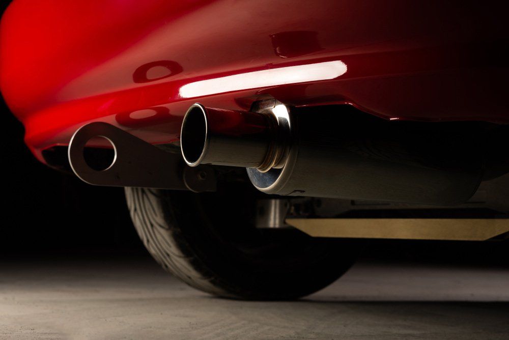 Closeup Of Red Car Exhaust Pipe — Airlie Beach Exhaust and Mechanical In Proserpine QLD