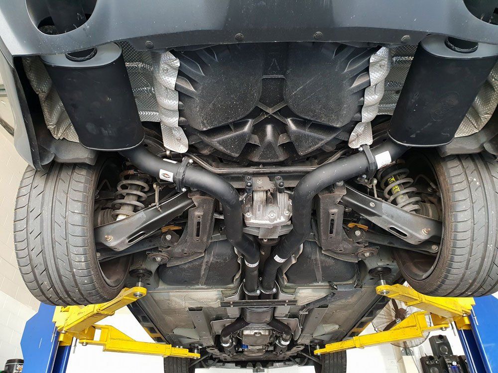 The Underside Of A Car Is Shown On A Lift — Airlie Beach Exhaust and Mechanical In Cannonvale, QLD