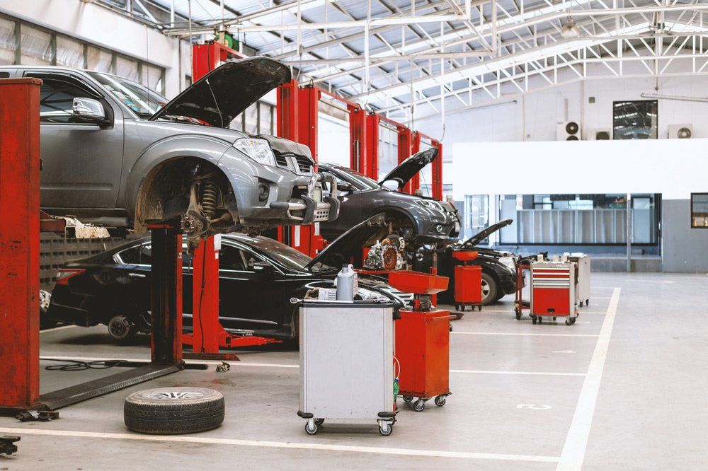A Car Is Sitting On A Lift In A Garage — Airlie Beach Exhaust and Mechanical In Bowen, QLD