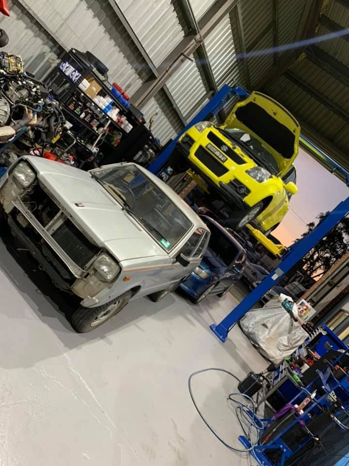 Silver Car in a Workshop With a Yellow Car on a Lift — D.A.G Automotive in Unanderra, NSW