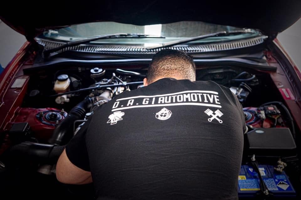 Mechanic Working on a Car Engine Under the Hood — D.A.G Automotive in Unanderra, NSW