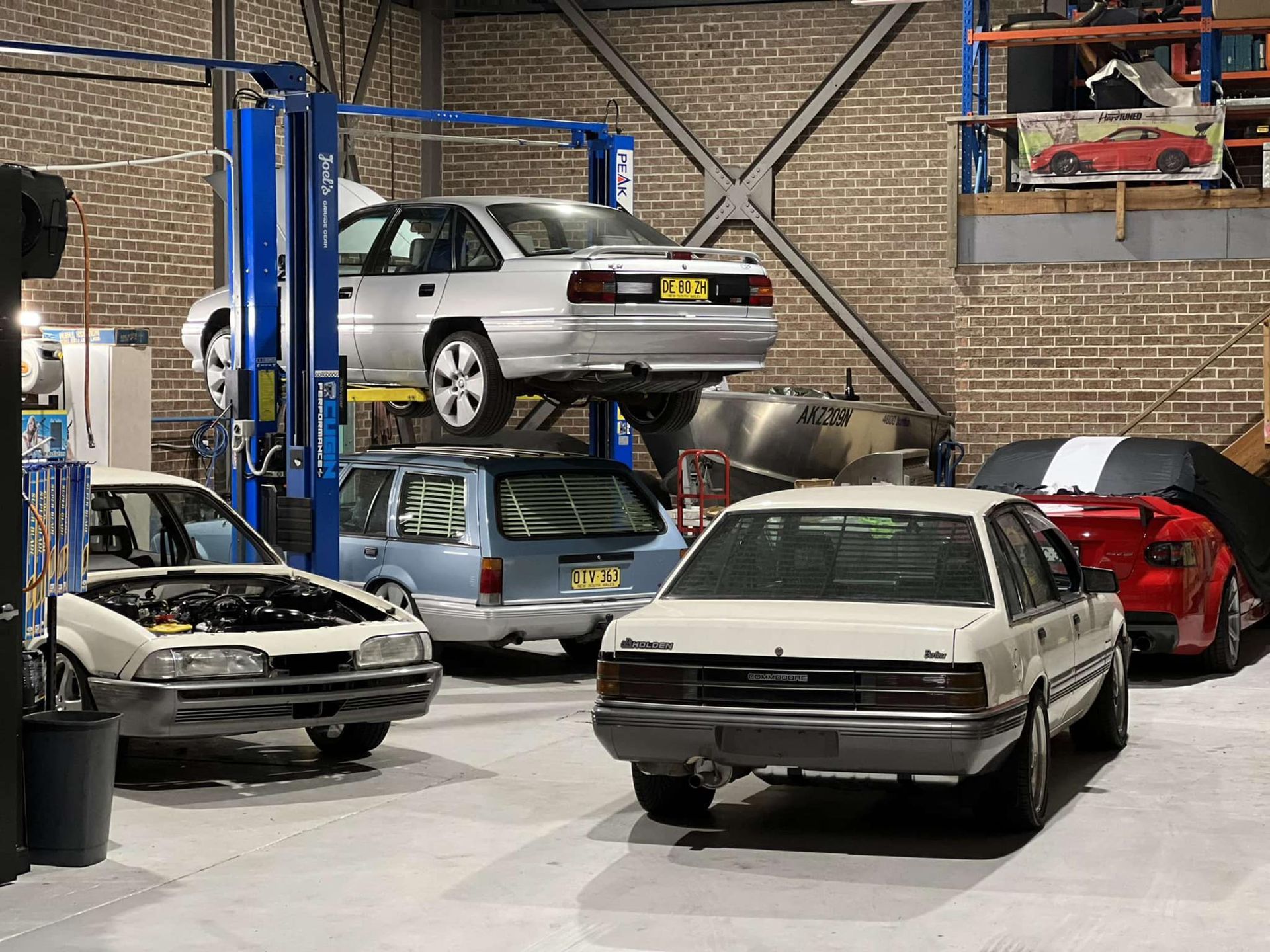Cars in a Garage, One on a Lift, Others on the Floor — D.A.G Automotive in Unanderra, NSW