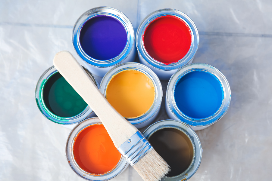 An image of 7 paint can with different colors of paint