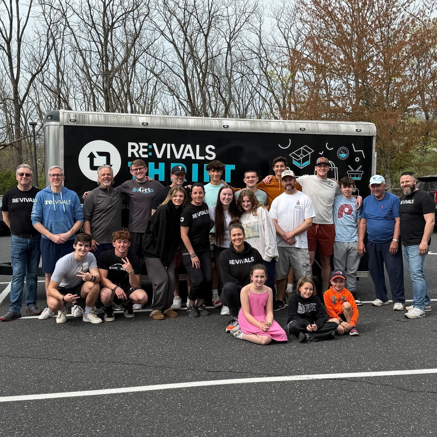 Group of people posing in front of a trailer with the word