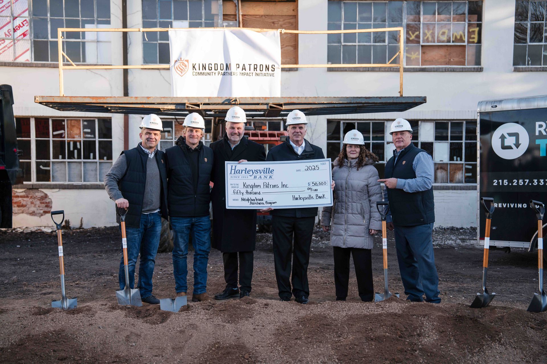 Group of people with shovels and large check at a ground breaking event.