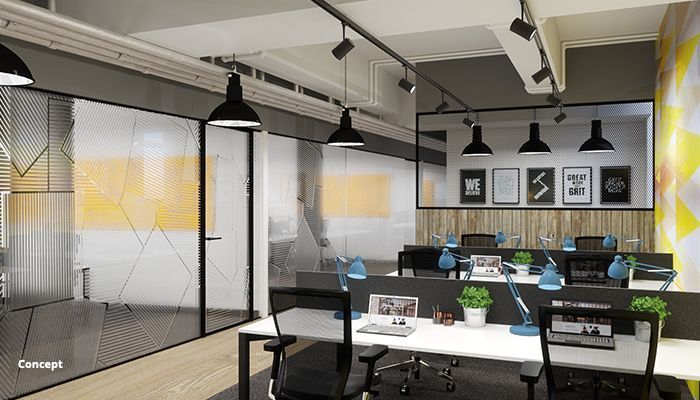 Modern office interior with desks, chairs, and framed art. Black pendant lights hang overhead.