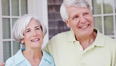 happy senior couple smiling outdoors
