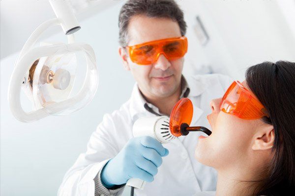 dentist using laser to clean teeth