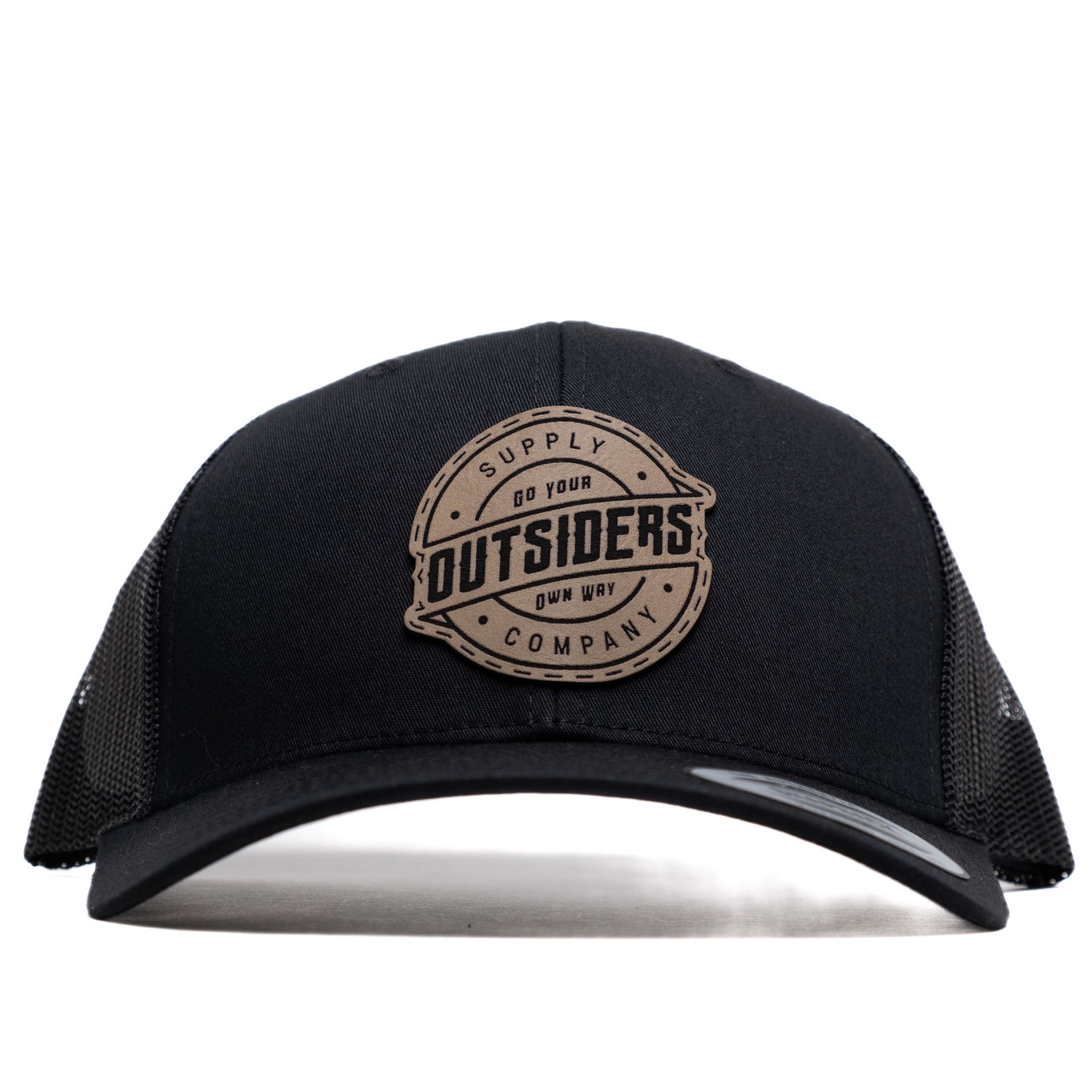 A black trucker hat with a leather patch that says outsiders company.