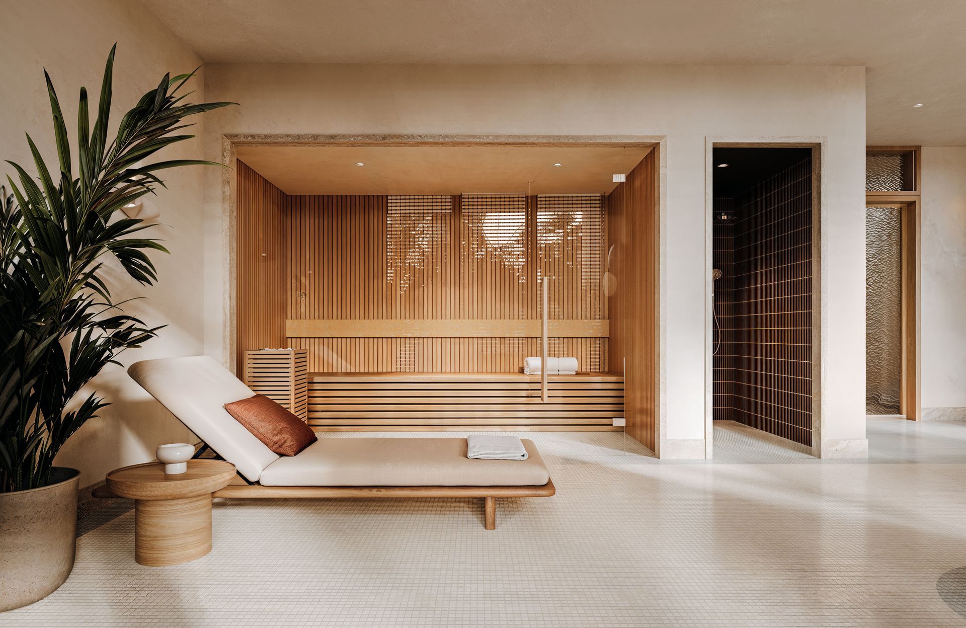 Spa room with wooden elements, lounge chairs, and plant, with neutral tones and soft lighting.