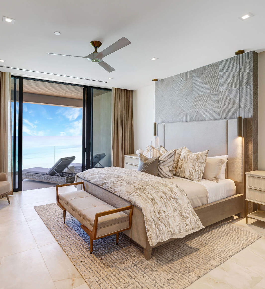 Luxurious bedroom with bed, Bahamas ocean view, and neutral color scheme.