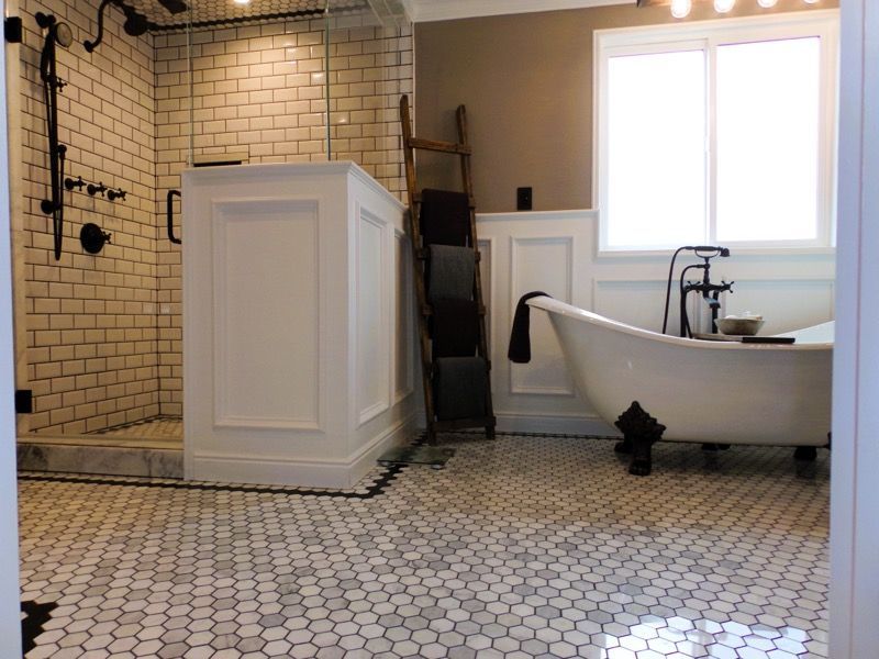 Bathroom with white tile floor, white and black fixtures, a glass shower, and a claw-foot tub.