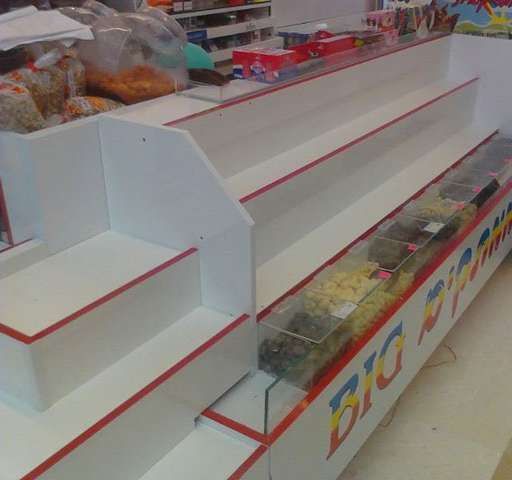 White and red candy display shelves in a store.