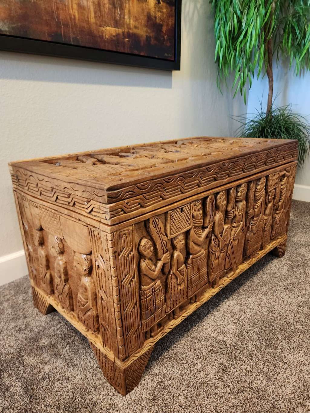 Ornate wooden chest with carved figures and patterns.