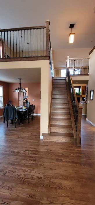 An open floor plan with a staircase, dining room, and loft with wood floors.
