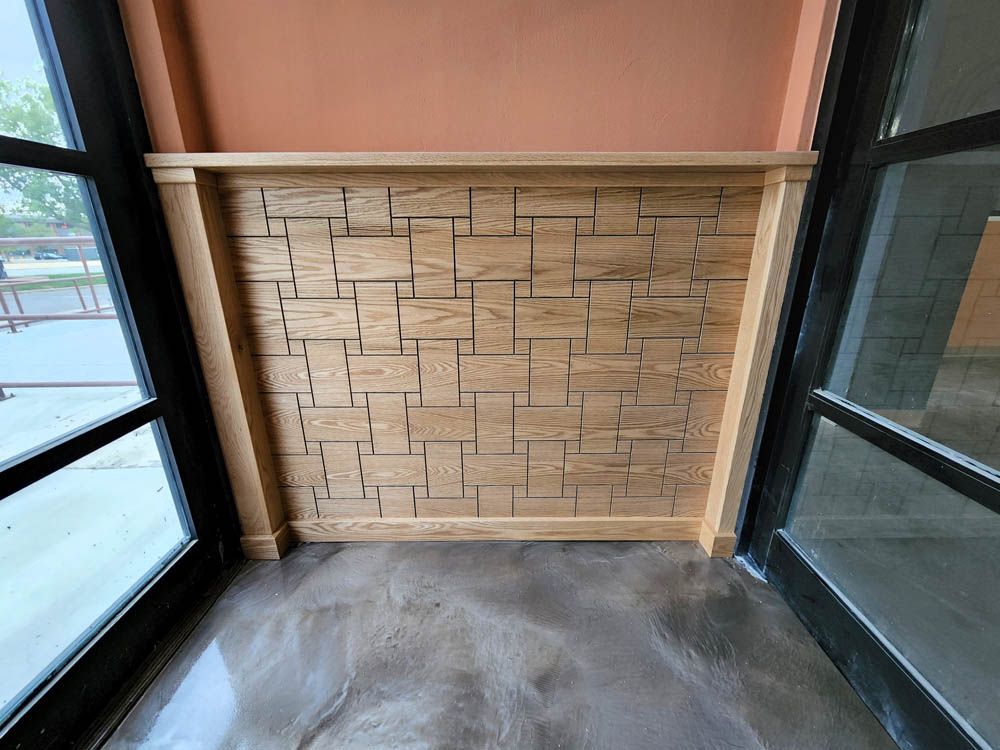 Wooden accent wall with various sized blocks between glass doors.