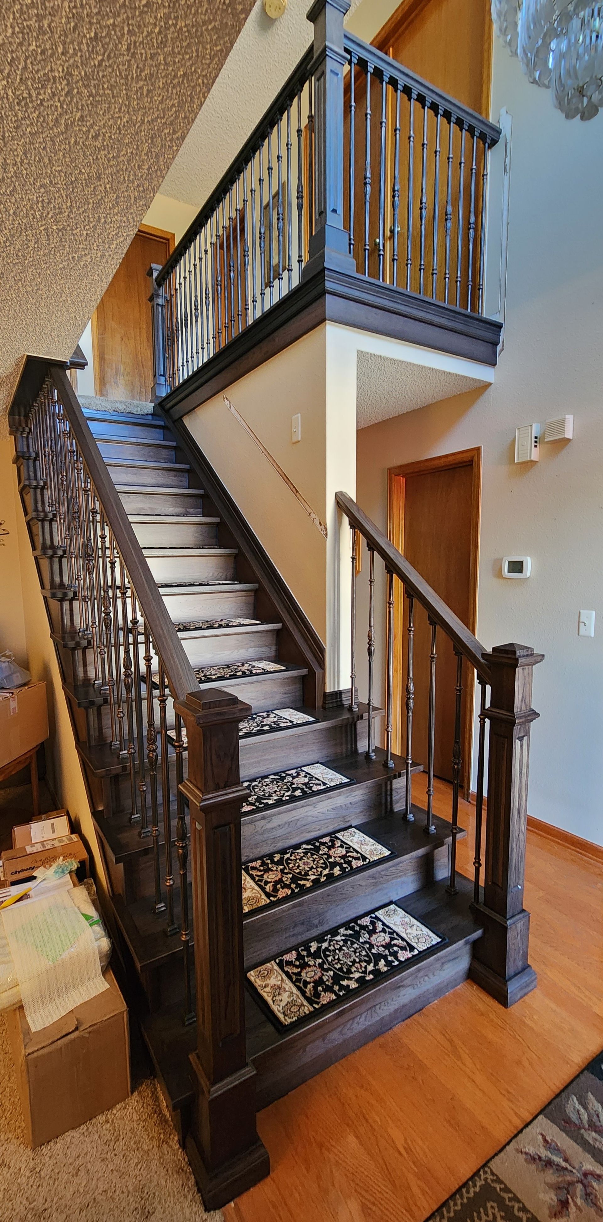 Staircase with wooden railing and metal bars, leading to a home's upper level.