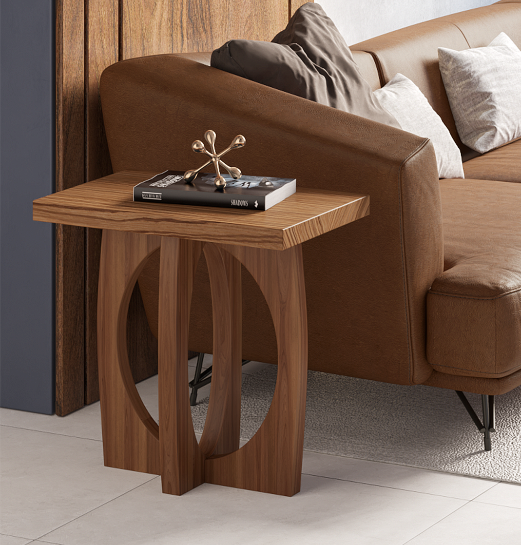 Wooden side table with a circular cut-out base next to a brown leather sofa.