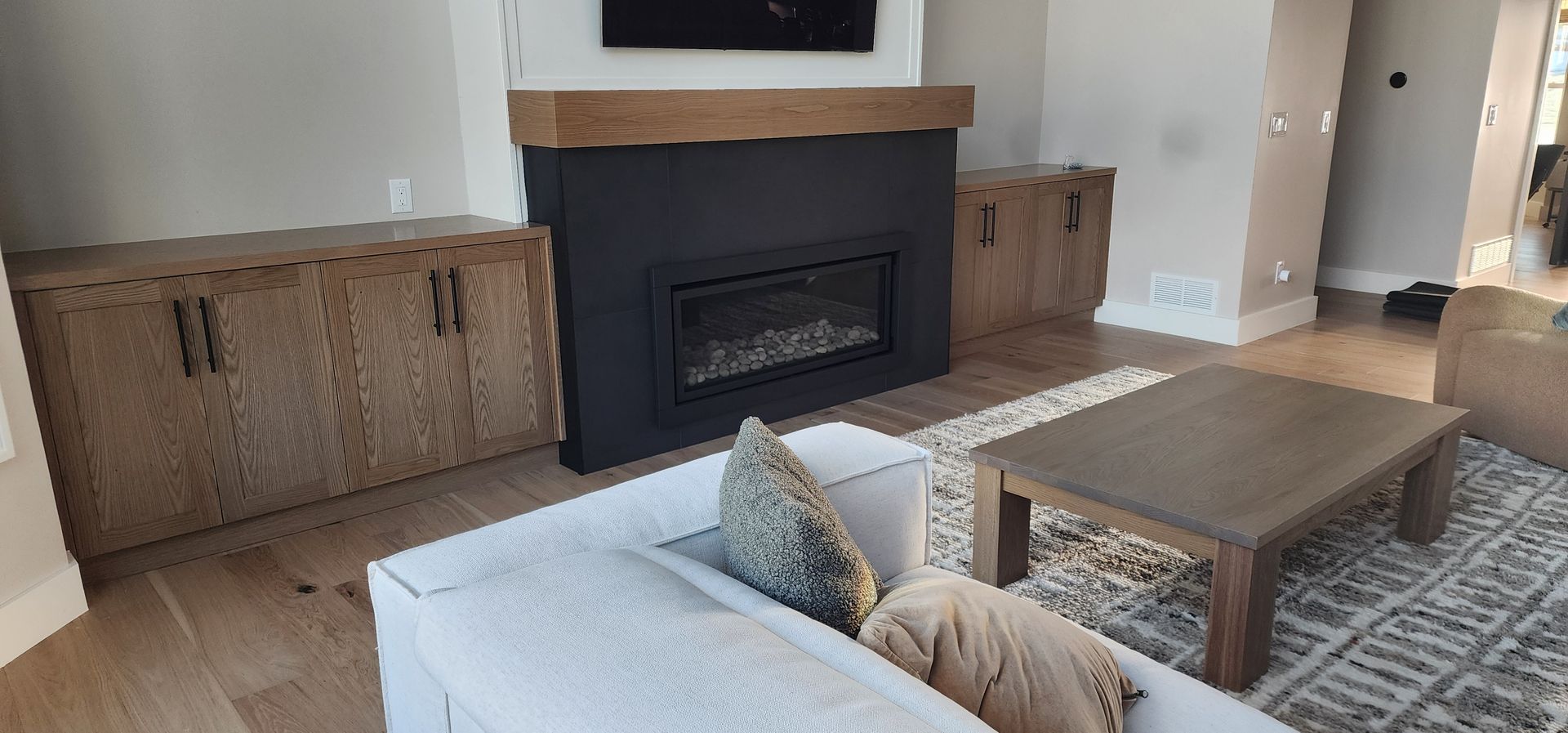 Living room with a fireplace, cabinets, couch, rug, and coffee table.