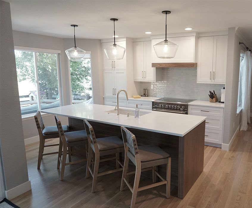 A kitchen with white cabinets , white counter tops , and a large island.